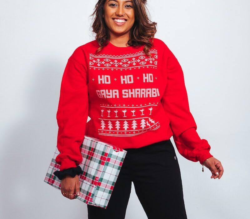 smiling woman wearing red sweater and black pants